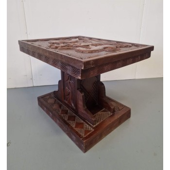 A coffee table with wood carvings